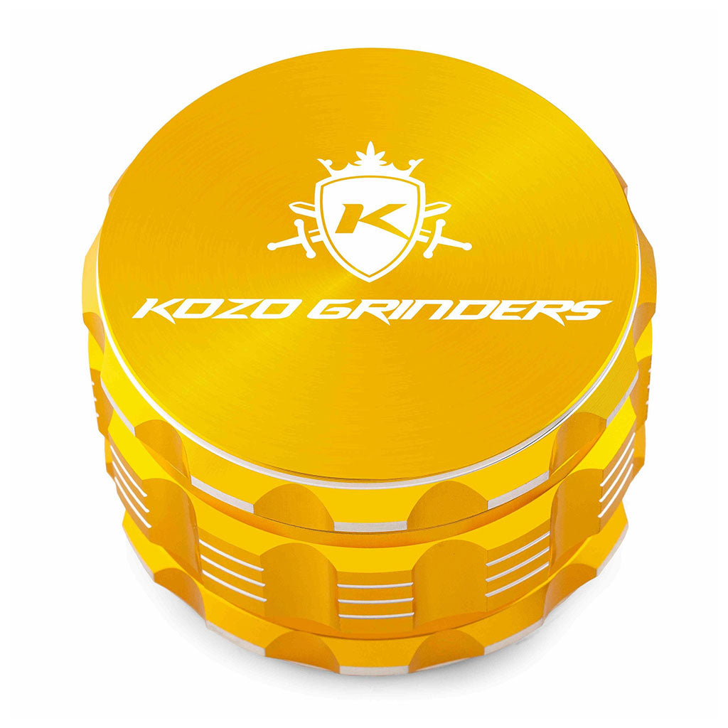 Kozo 3 inch four-piece anodized aluminum grinder in gold, closed front view of the body with the Kozo logo lid