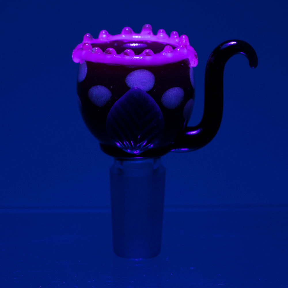 Empire Glassworks Fire Plant Bowl Piece glowing under UV light, front view on blue background