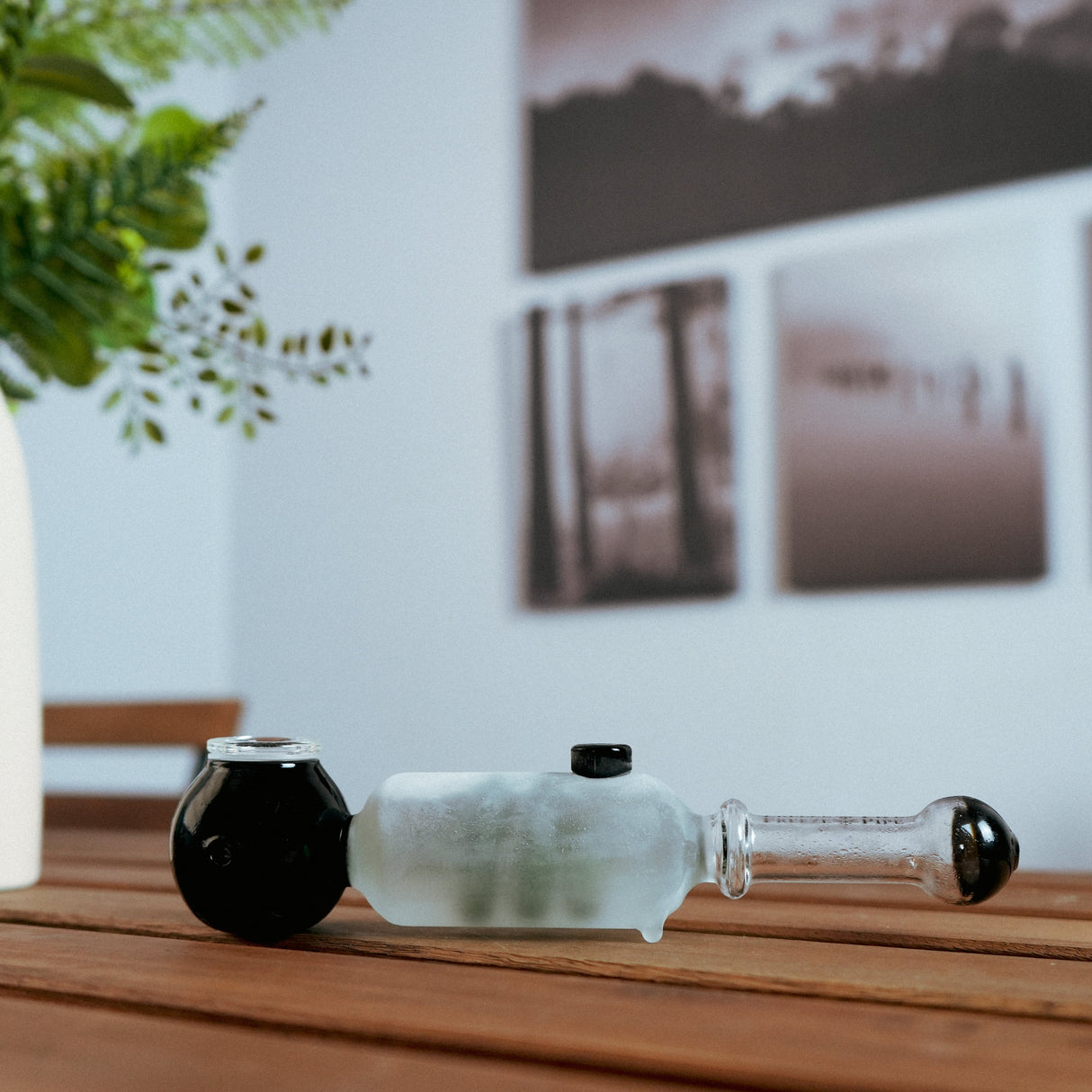 Freeze Pipe hand pipe in black and white, glycerin-filled for cool smoke, side view on wooden surface