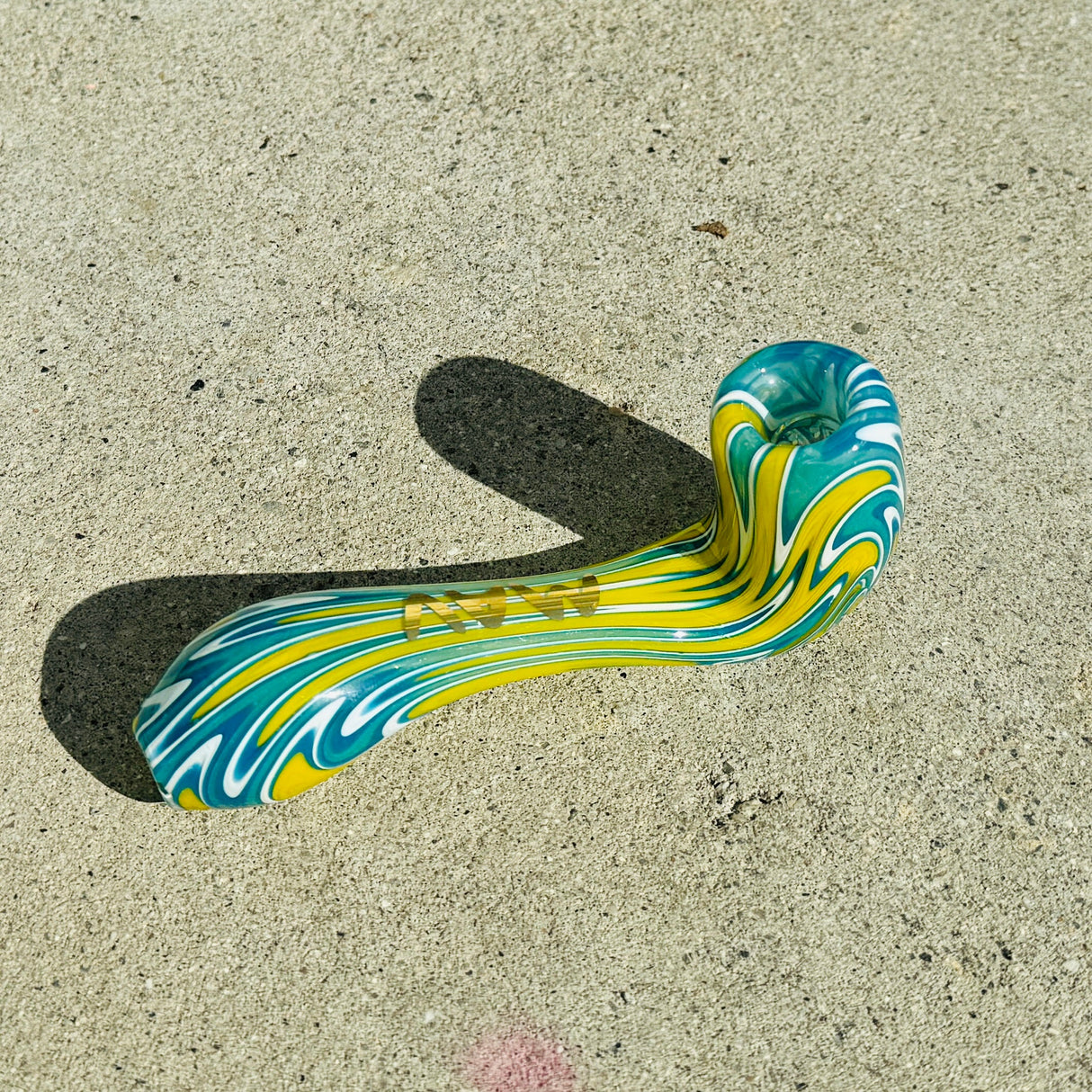 MAV Glass Wig Wag Golden 5β Sherlock Hand Pipe with Colored Swirls on Concrete