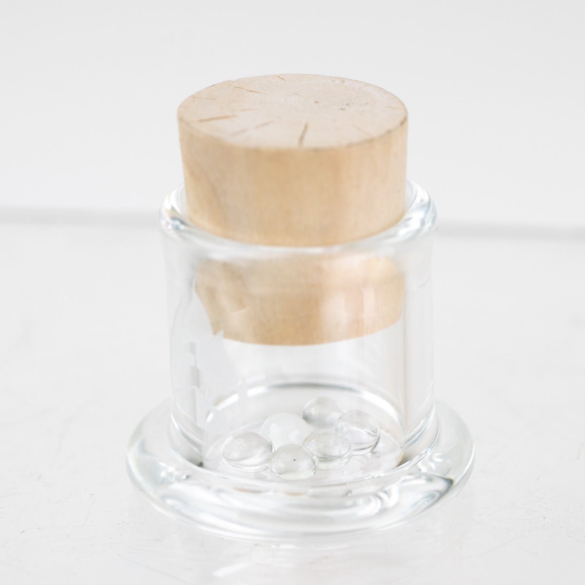 Empire Glassworks UV terp pearls in reusable glass container carb cap stand