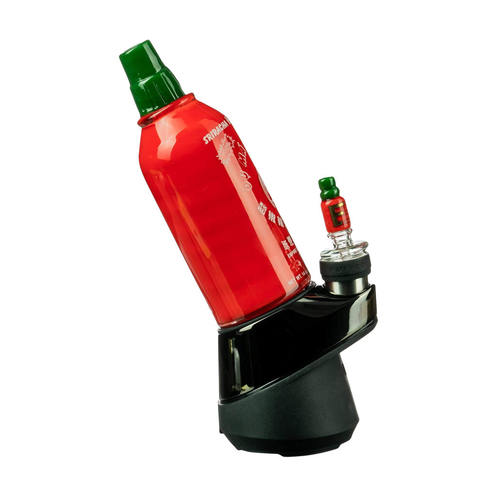 Empire Glassworks Sriracha Glass Bottle Attachment for PuffCo Peak & Pro on a black stand, side view