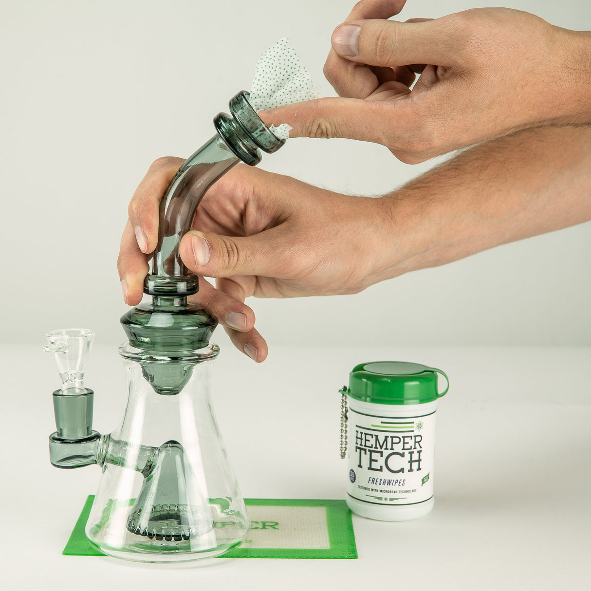 Hemper Tech Alcohol Freshwipes Bucket next to a glass bong being cleaned