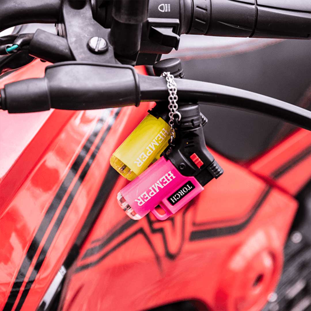 Hemper Windproof Torch Lighters V2 in blue, green, and yellow, attached to bike handlebar