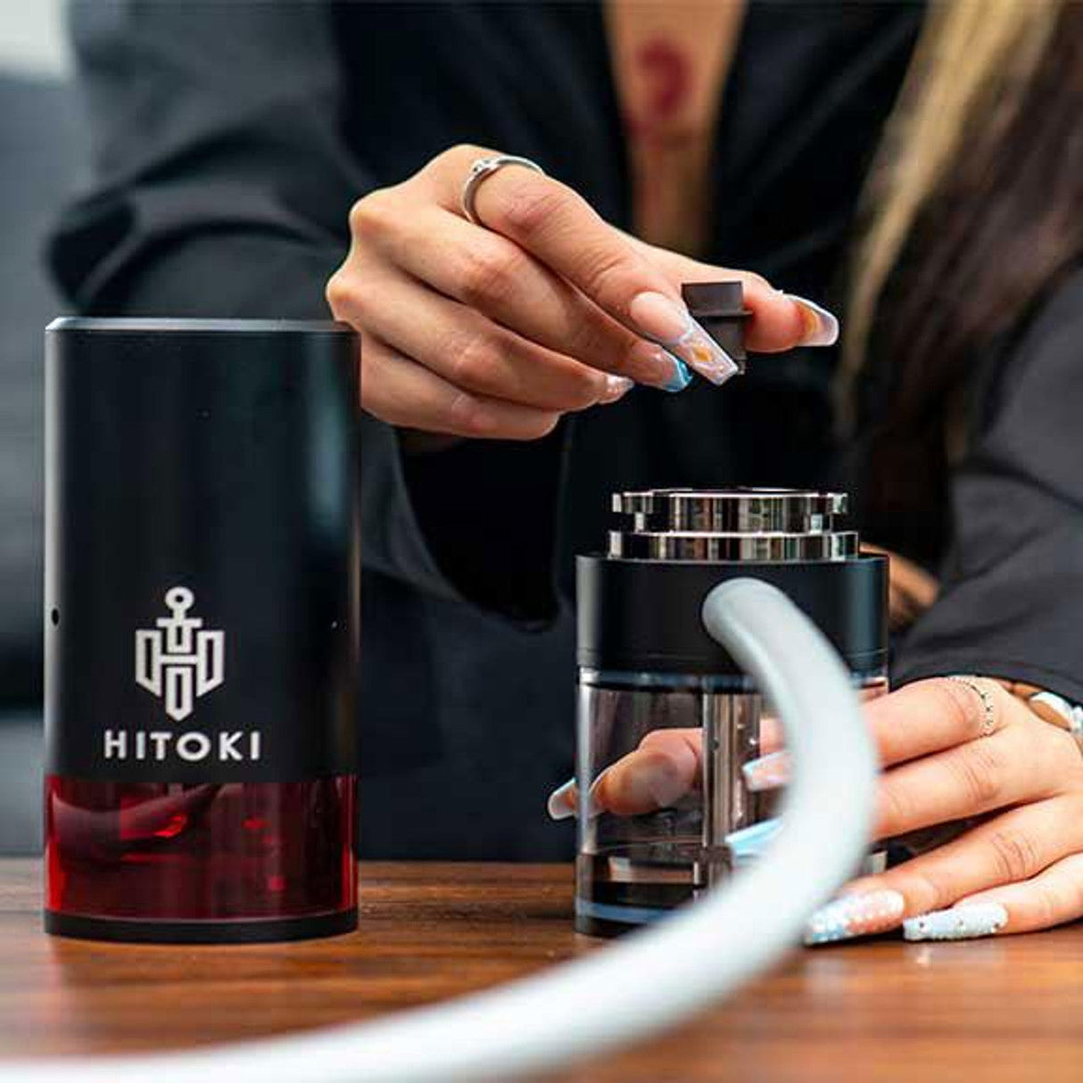 Hitoki Trident Laser Water Pipe 2.0 in Black, showcased with a person loading the chamber