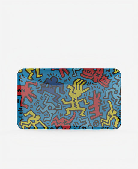 K.Haring Glass Rolling Tray with vibrant abstract figures on a blue background, front view