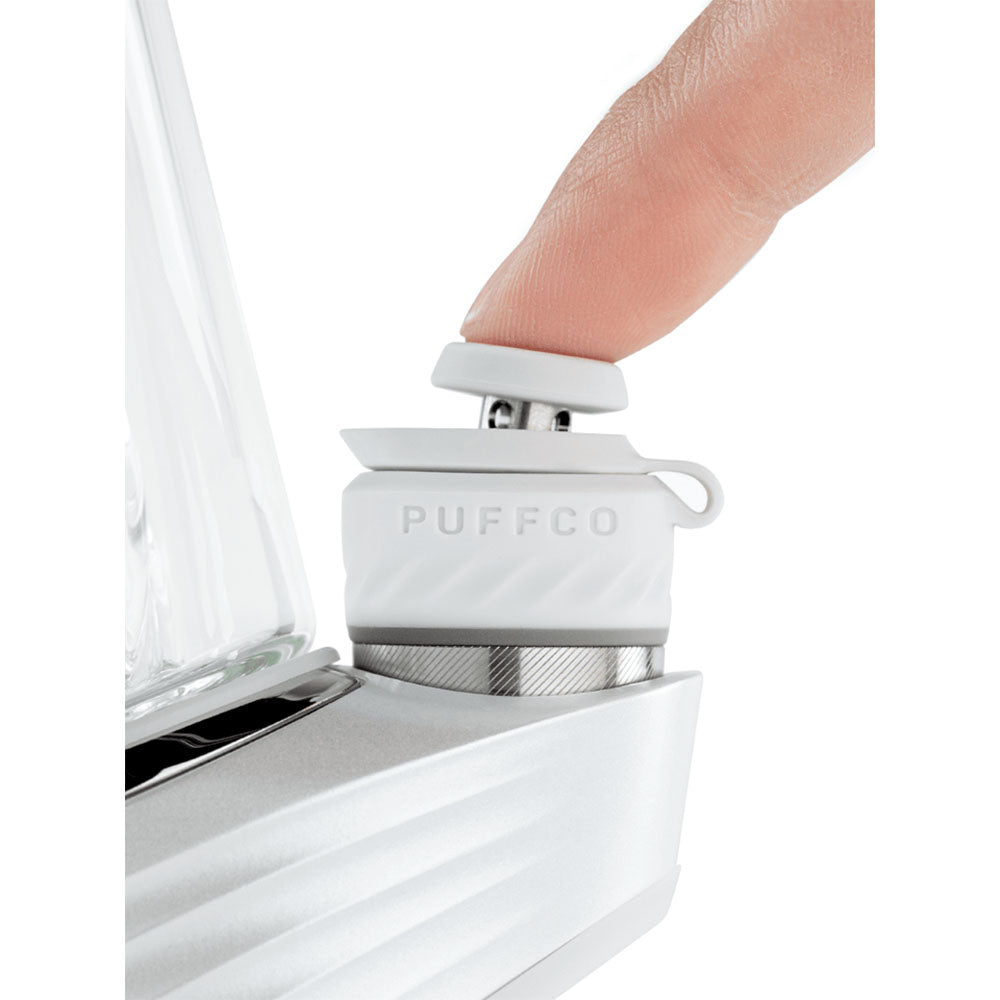 Close-up of Puffco Peak Pro Vaporizer with a finger on the power button, showcasing sleek design