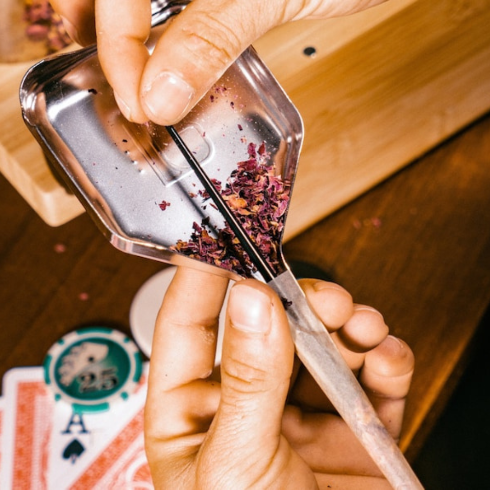 Close-up of TIGER pre-rolled cone loader by Blue Bus Fine Tools, filled with herbs, in use