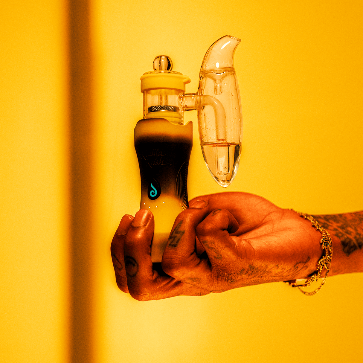 Dr Dabber XS Khalifa Kush Limited Edition Vaporizer in hand against yellow background