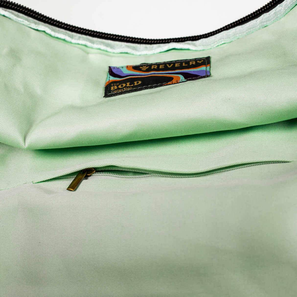 Close-up of The Drifter Smell Proof Rolltop Backpack by Revelry Supply with logo detail