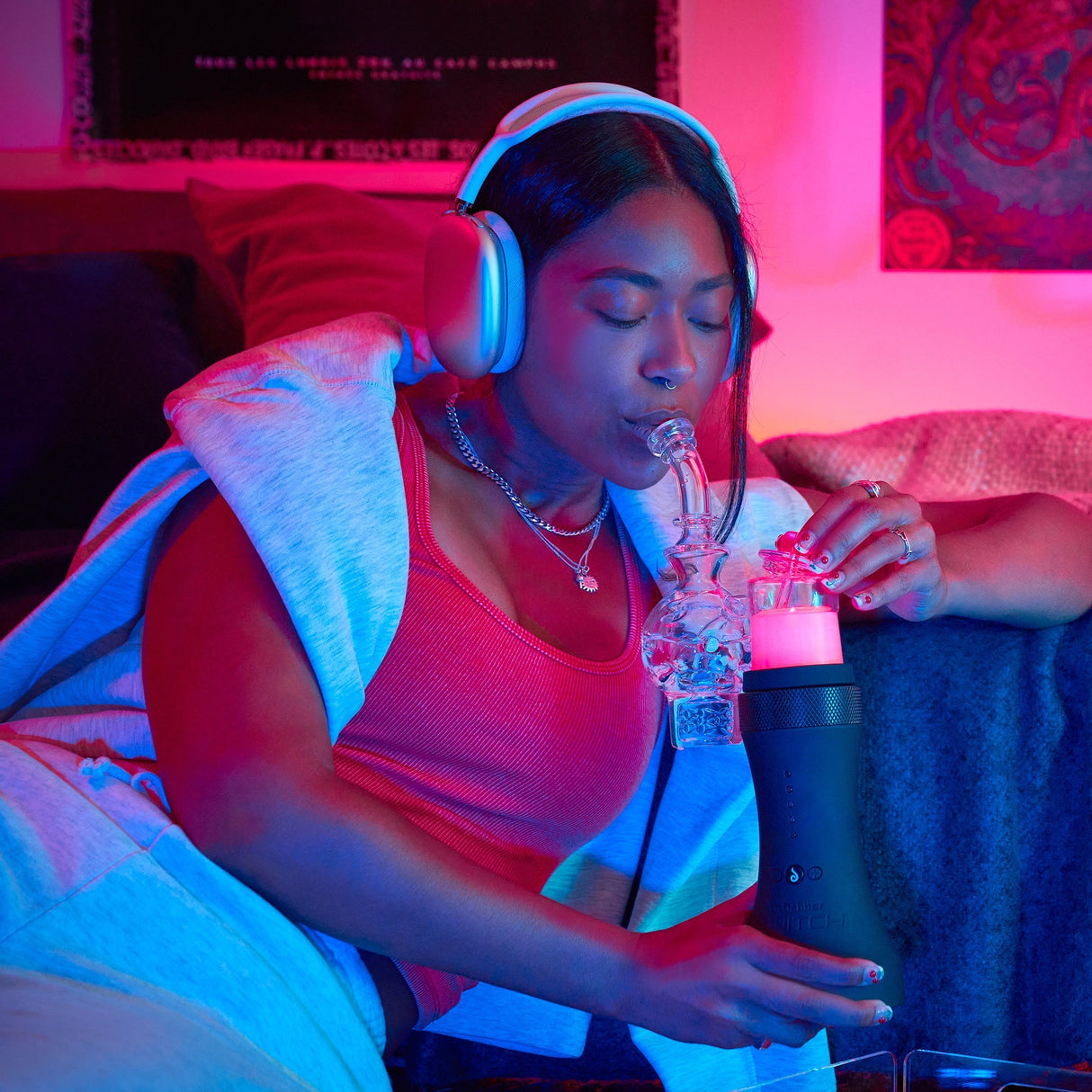 Woman using Dr. Dabber Switch™ portable e-rig with ceramic insert for dabbing, in a cozy indoor setting
