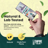 Hand holding BENNY LITE Papers by Empire Rolling, resembling $100 bills, natural and lab tested