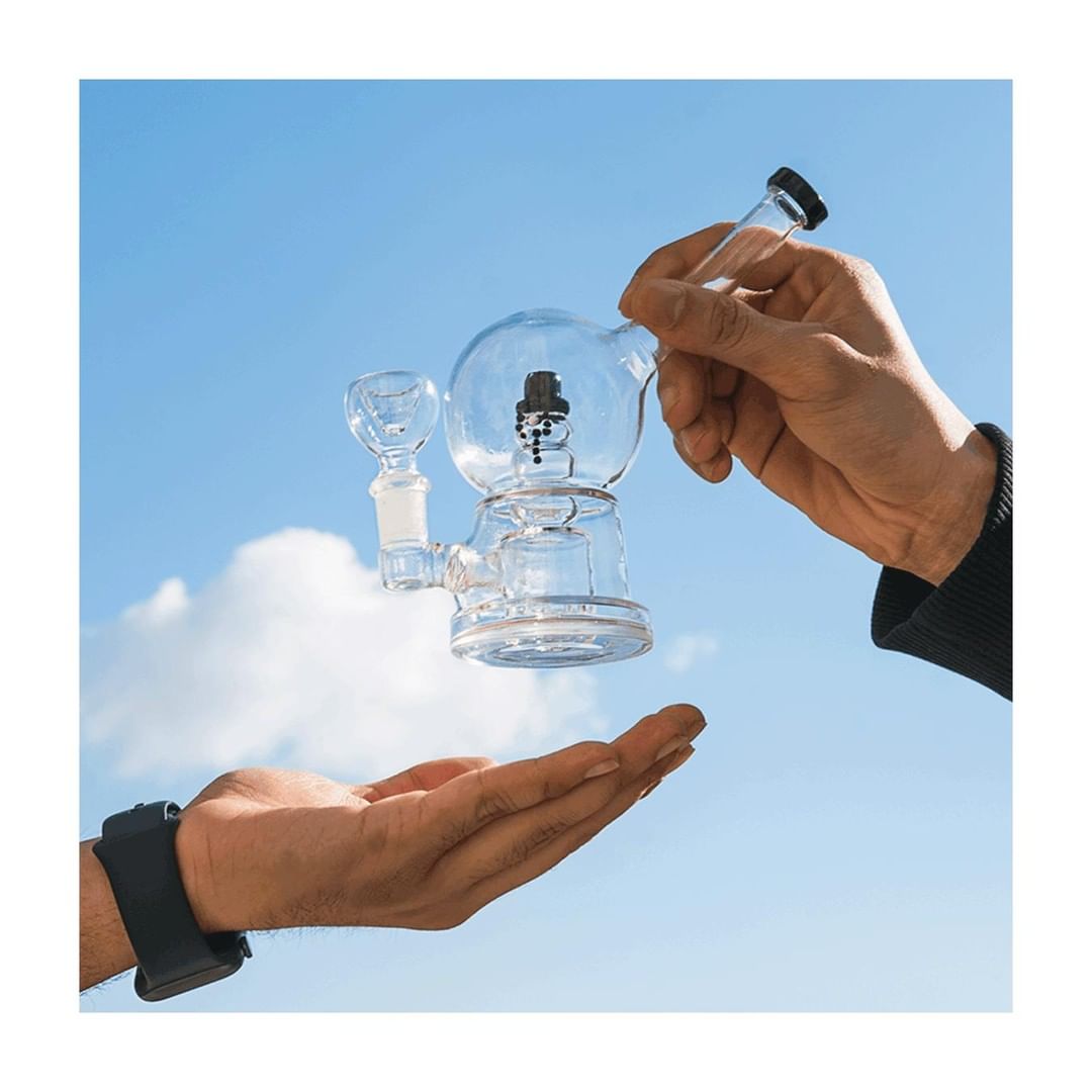 Hemper Snow Globe Bong with Showerhead Percolator held against sky, clear glass, 7" height
