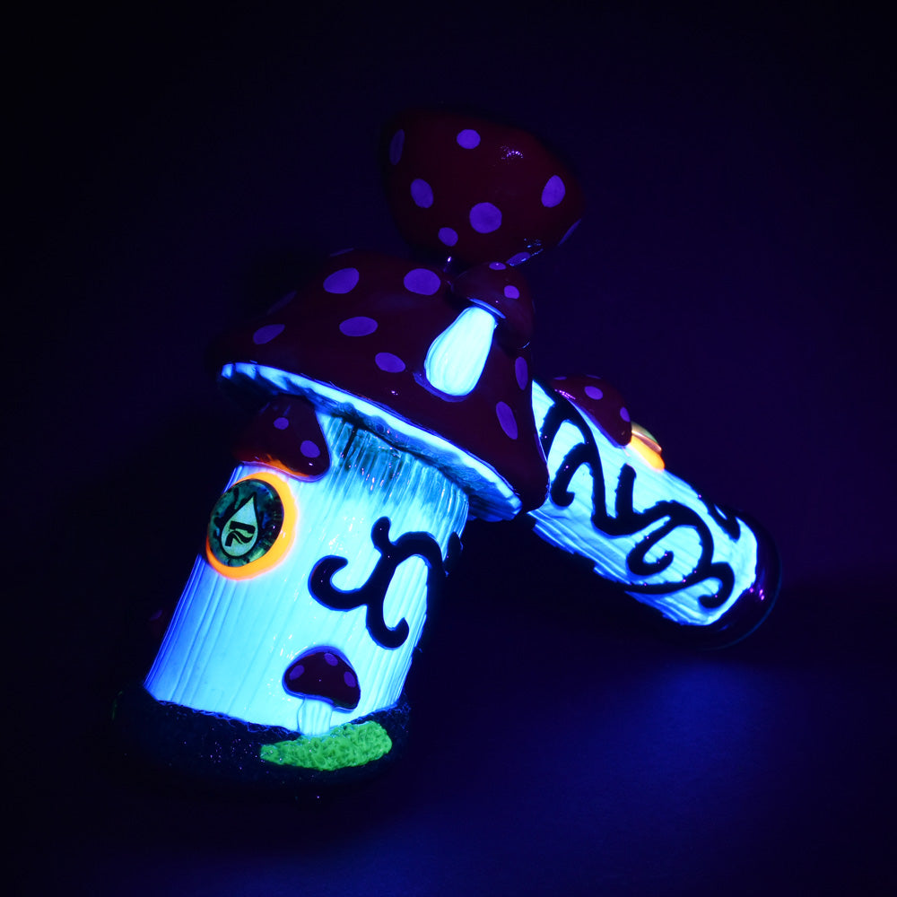 Pulsar Shroom House Bubbler Pipe with glow-in-the-dark design, angled view on black background