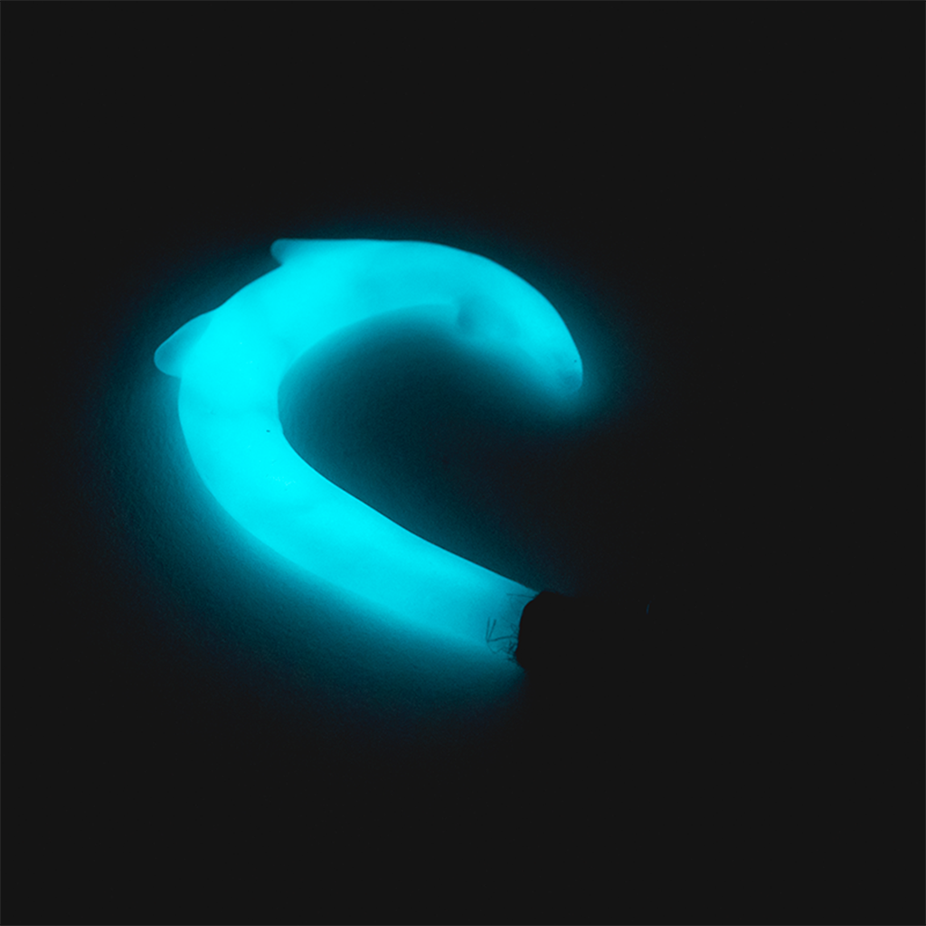 Empire Glassworks Hook Dab Tool glowing in dark, close-up view