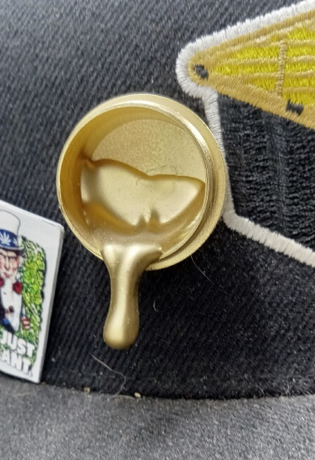 StonerDays Exclusive Dab Bucket Pin on fabric, with Its Just A Plant Pin in view