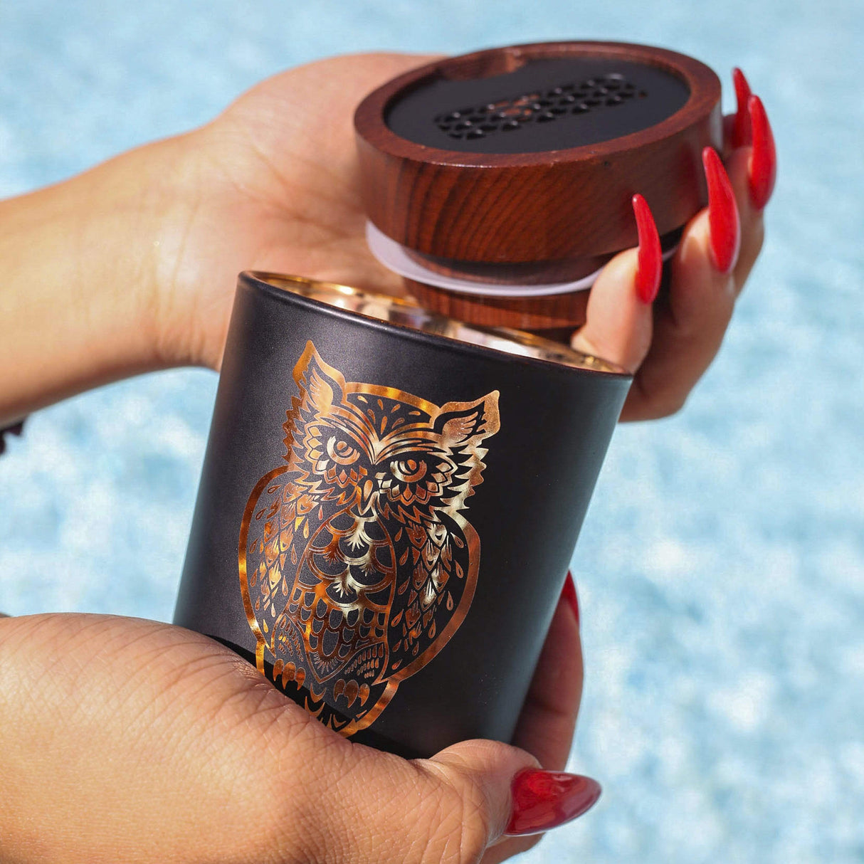Hand holding Daze of the Dead Yellow SmartStash with intricate owl design, compact and portable