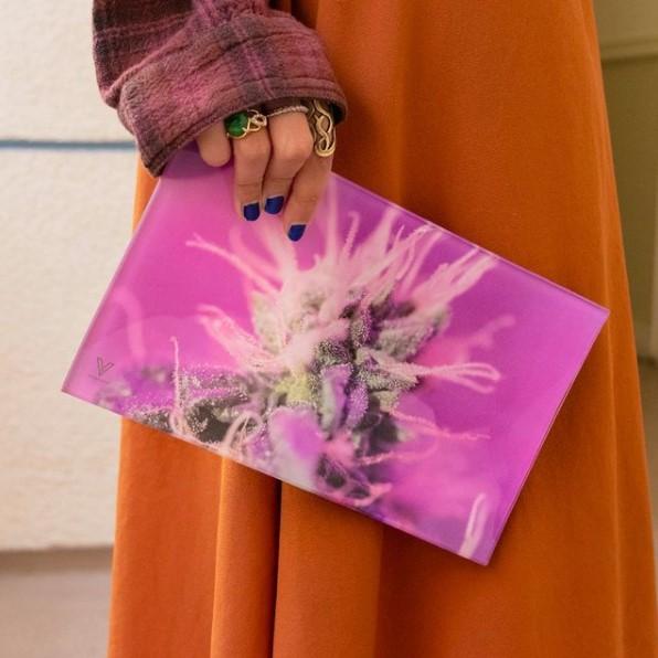 Person holding a V Syndicate Pink Lemonade Glass Rollin' Tray with vibrant cannabis design