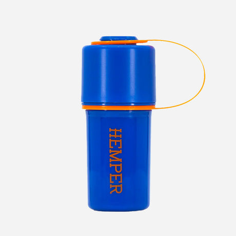 A Stash Jar in blue with orange accents. It has a cylindrical shape, a secure screw-on lid with a loop for easy carrying, and "HEMPER" printed vertically on the body. Designed for storing herbs discreetly.