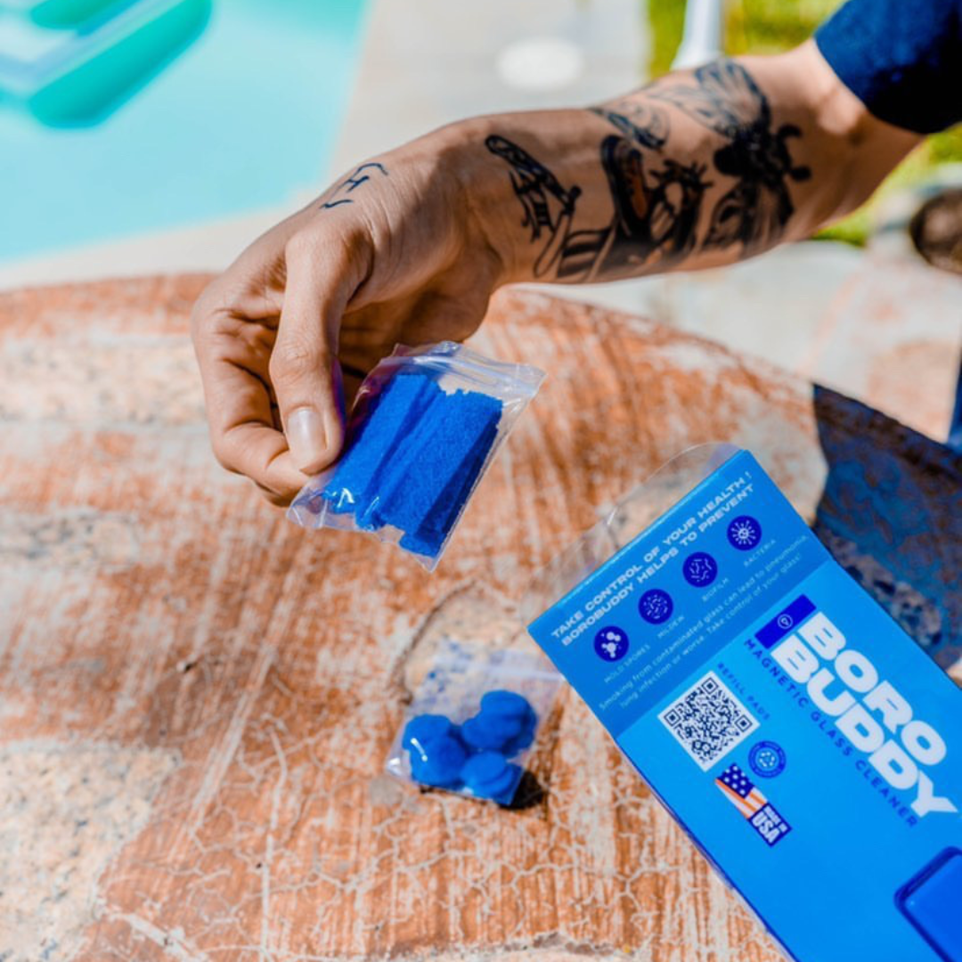 Person using BoroBuddy™ Magnetic Cleaner with blue pads for easy bong maintenance