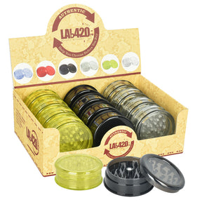 Display box of 2.5" Acrylic Grinders in assorted colors including amber, black, and green