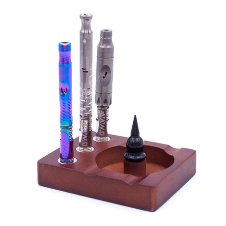 Wooden Debowler Base with three DynaVap devices, front view on a solid background