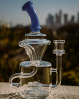 8" AFM Mighty Can Recycler Dab Rig with blue accents, side view on outdoor backdrop