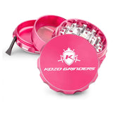 Kozo 3 inch four-piece anodized aluminum grinder in pink, split into four pieces with the pollen scraper