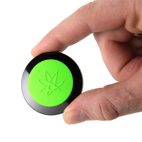 420 Science Wax Wallet in hand, green and black silicone, portable 1.75" x 0.5" concentrate storage