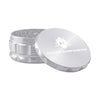 Kozo 4 inch four-piece anodized aluminum grinder in silver, lid tilted open beside the toothed grinding chamber