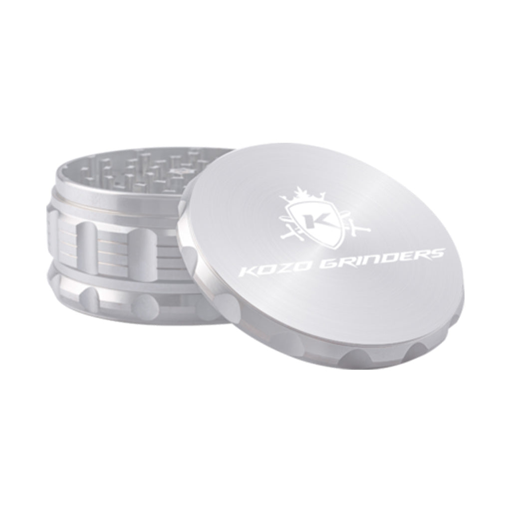 Kozo 4 inch four-piece anodized aluminum grinder in silver, lid tilted open beside the toothed grinding chamber