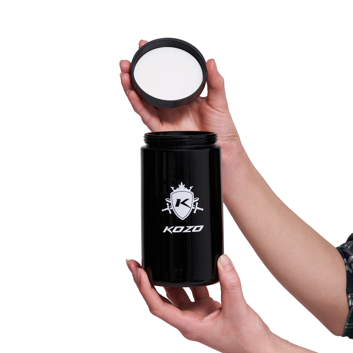 Kozo 1 oz black UV glass storage jar with a hand lifting off the airtight lid to show the opening