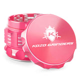 Kozo 2 inch aircraft-grade aluminum grinder in pink, angled view with the lid tilted open and logo visible