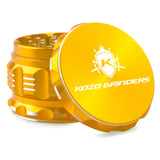 Kozo 2.5 inch aircraft-grade aluminum grinder in gold, angled view with the lid tilted open and logo visible