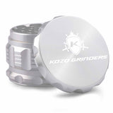 Kozo 2.5 inch aircraft-grade aluminum grinder in silver, angled view with the lid tilted open and logo visible
