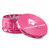 Kozo 4 inch aircraft-grade aluminum grinder in pink, angled view with the lid tilted open and logo visible