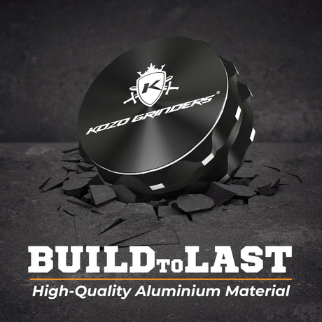 Kozo 2.5 inch two-piece non-stick aluminum grinder in black on cracked stone with a Build to Last aluminum callout