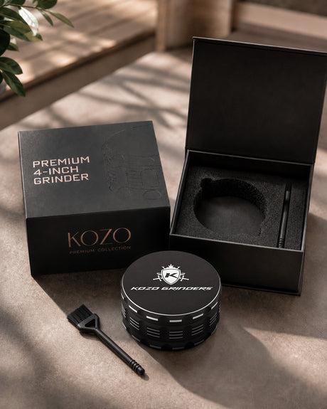 Kozo 4 inch four-piece non-stick aluminum grinder in black, in a gift box beside a small cleaning brush