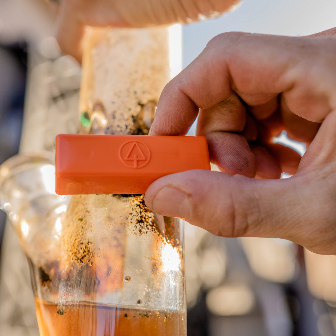 Close-up of BoroBuddy™ Magnetic Cleaner by Snowtree in use on a glass bong