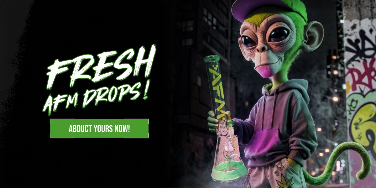 A stylized promotional graphic with the text 'FRESH AFM DROPS!' and 'ABDUCT YOURS NOW!' on the left, and a cartoon green monkey character wearing a purple hoodie and cap holding a green AFM bong on the right against a dark city street background.