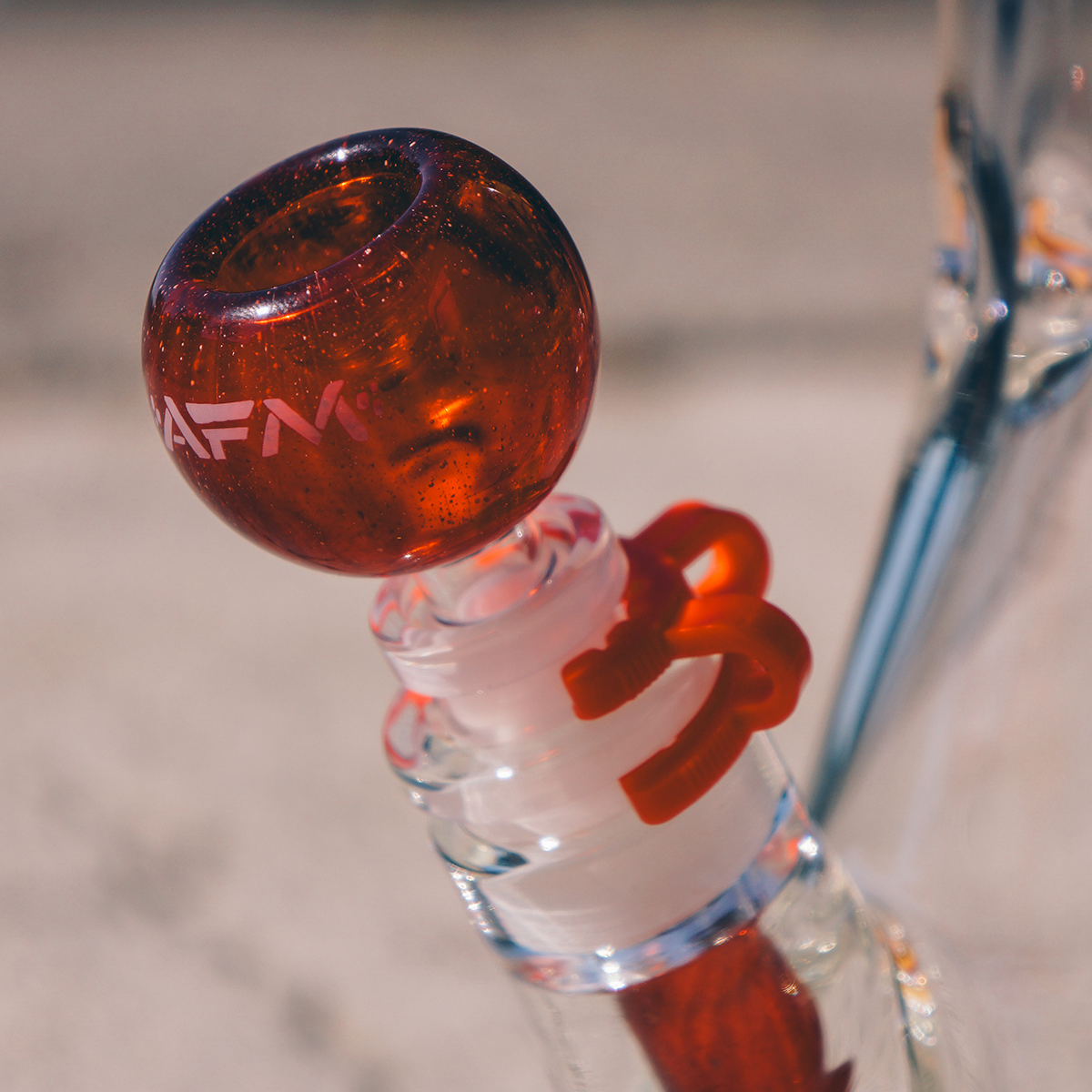 Close-up of AFM Phoenix Clear Glass Beaker Bong with Red Accents and Logo