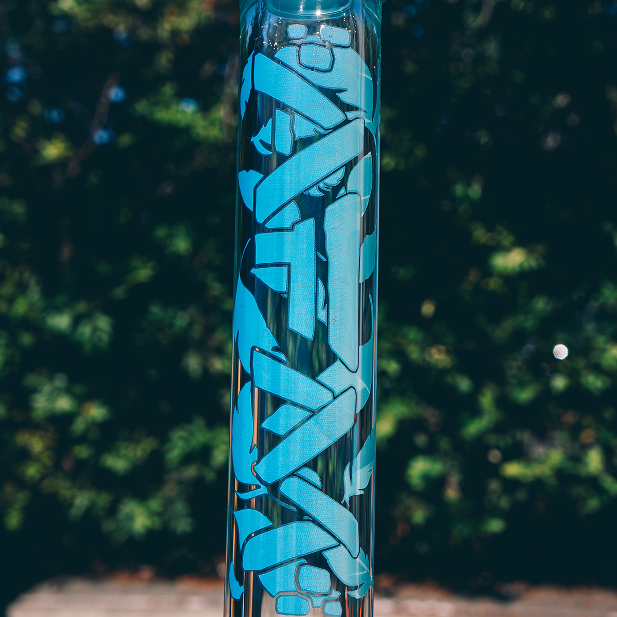 Close-up of 18" AFM Phoenix 9mm Clear Glass Beaker Bong with blue logo detail