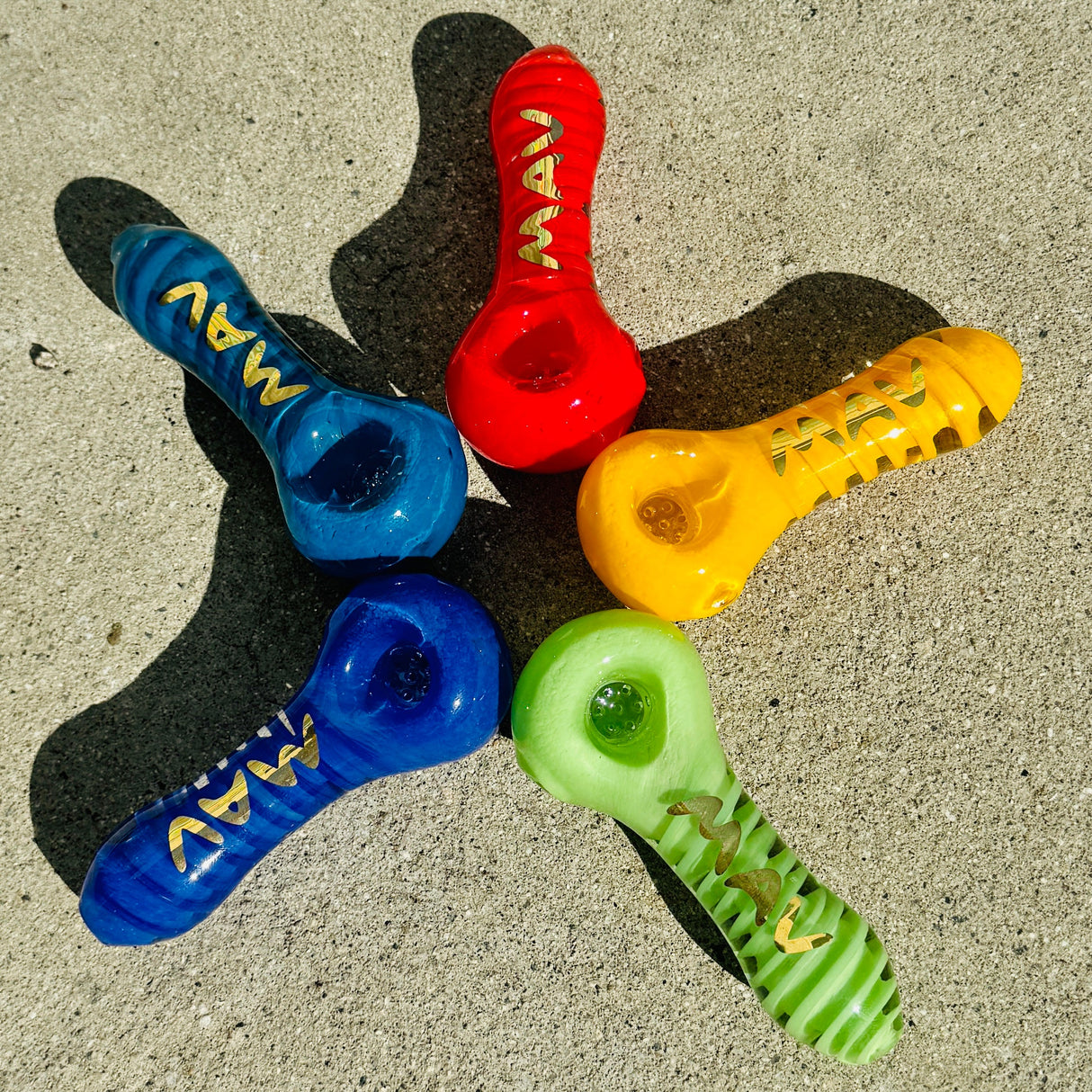 MAV Glass Twisted Frit Hand Pipes in Various Colors - Top View on Concrete