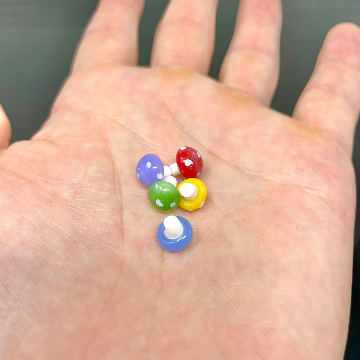 AFM Mushroom Marble Pearls, assorted colors, held in palm for scale, borosilicate glass accessory