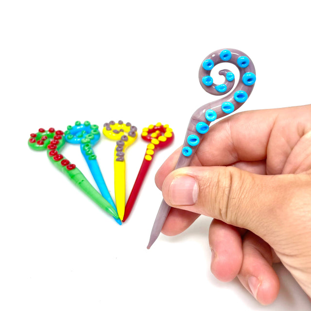 AFM Octopus Glass Dabber Tool in hand, showcasing intricate colored glass design, ideal for dab rigs