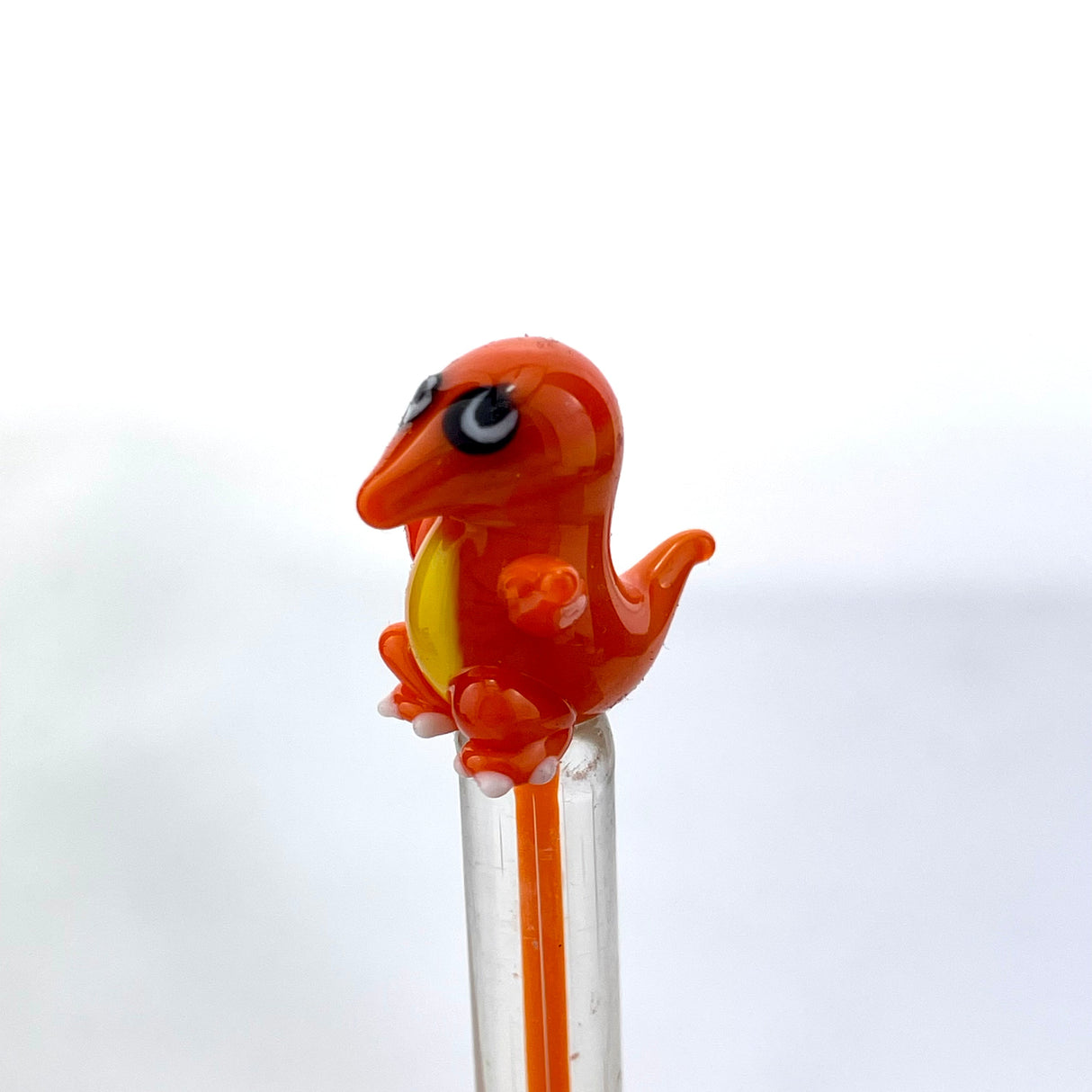 AFM Charizard-inspired glass dabber tool in vibrant orange, close-up on white background