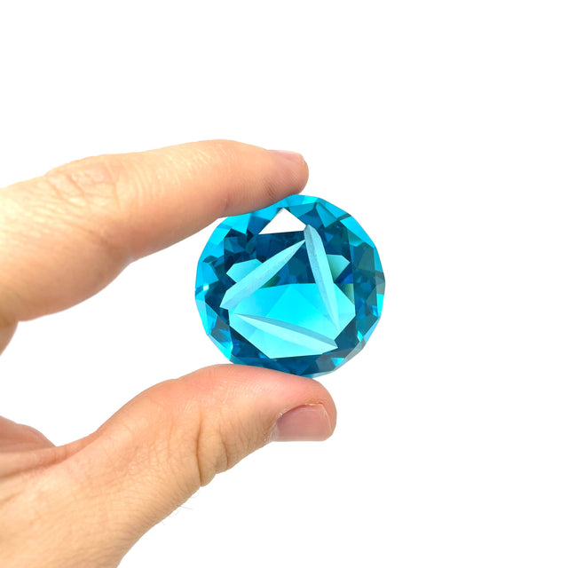 AFM Diamond Spinner Cap in vibrant blue, held between fingers showcasing its intricate facets