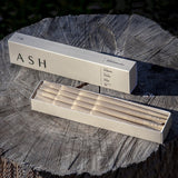 Ash Organic Pre-Rolled Cones in a 12-pack box, displayed on a wooden stump, perfect for dry herbs