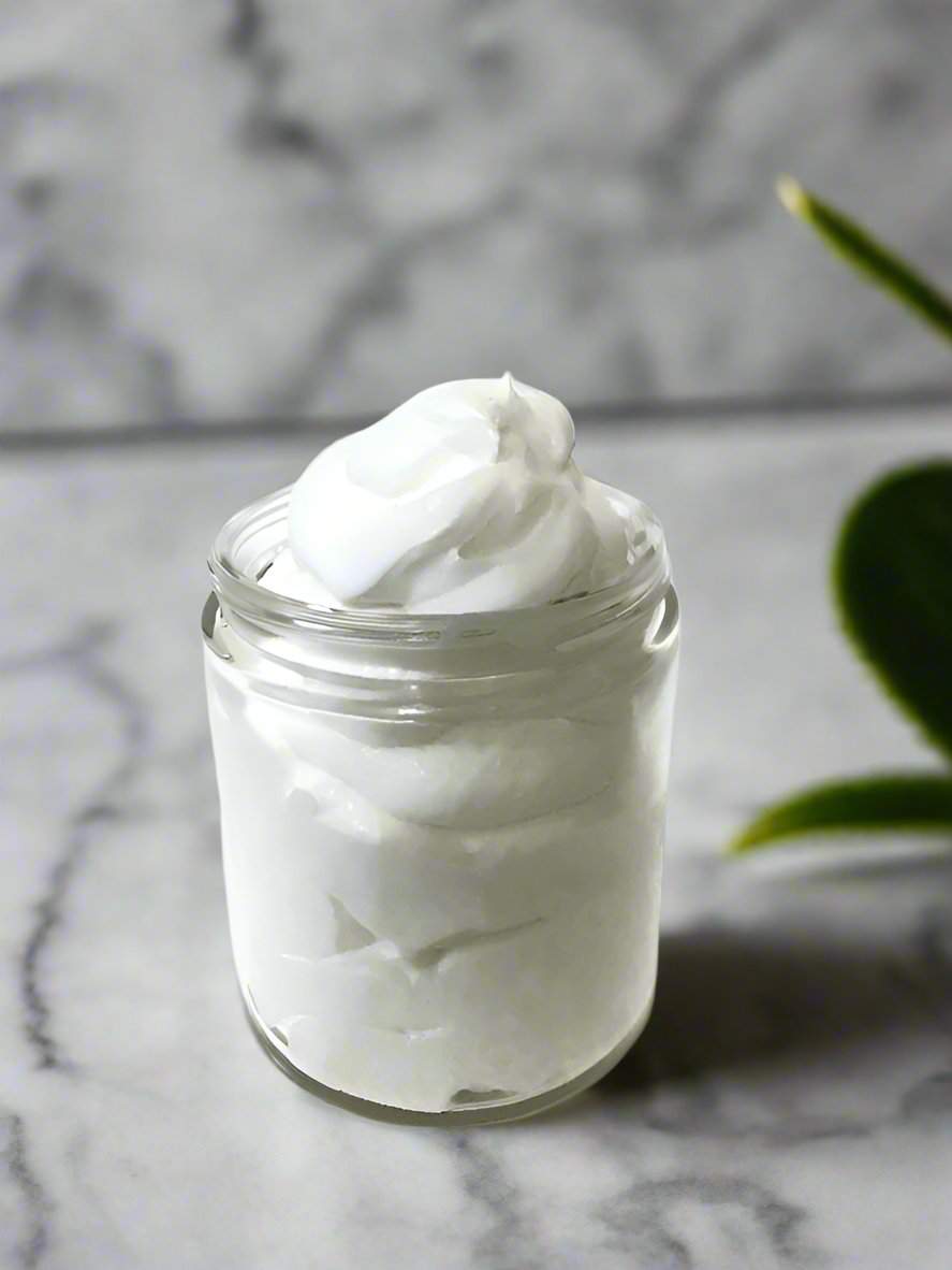 Elite Creed Natural Honeysuckle Body Butter with CBD, open jar on marble background