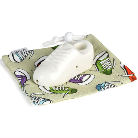 Art of Smoke white sneaker-shaped ceramic pipe on patterned carry bag, ideal for dry herbs